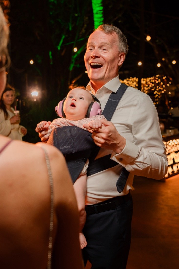 A guest laughing with a baby at the evening reception