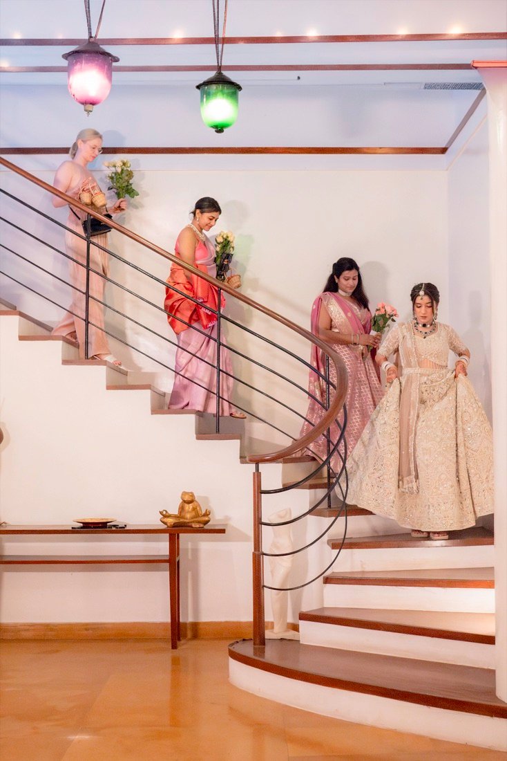 Bhavna walking down a staircase with her bridesmaids on her wedding day