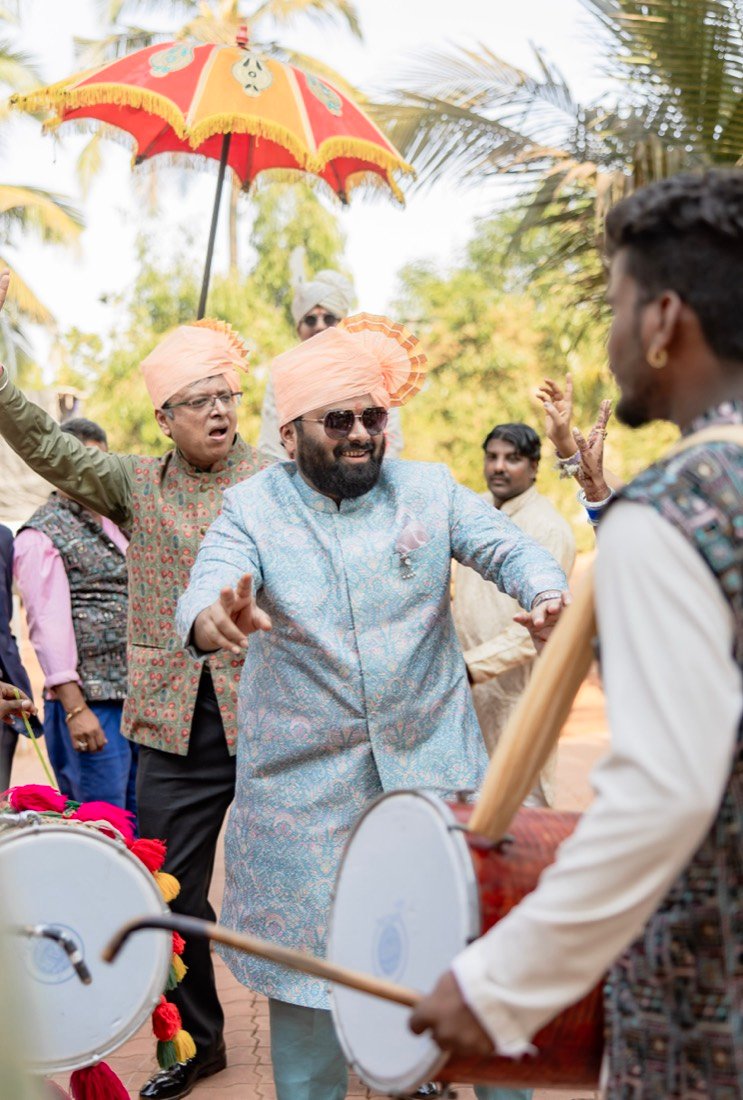 Guests in peach turbans dancing to the dhol at a baraat in Goa